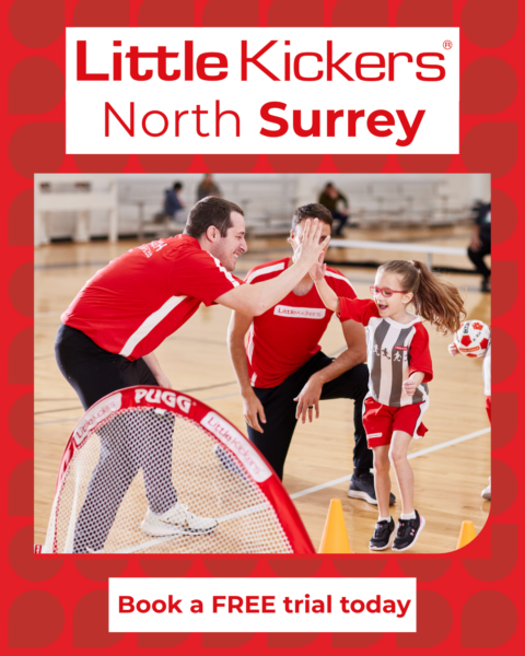 Little Kickers North Surrey coach giving a high five to a young child during a fun indoor football class for toddlers and children.
